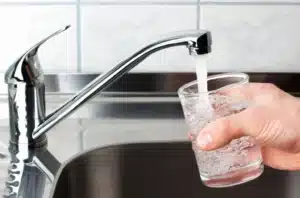 Vaso llenándose con agua limpia gracias a sistemas de tratamiento residencial y comercial